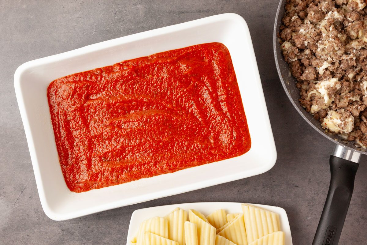 Step 4 of Taste of Home Meaty Manicotti is to spread 2 cups of the spaghetti sauce in a greased 13x9-inch baking dish.