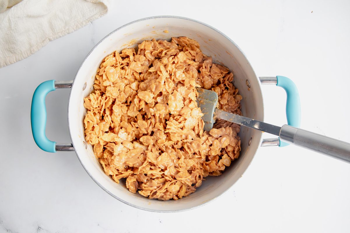 Overhead shot for Taste of Home Peanut Butter Cornflake Cookies with cornflakes and peanut butter mixture being tossed together.
