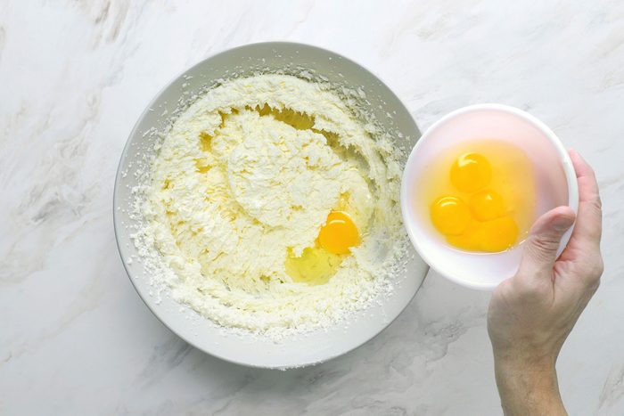 Added egg yolks into the mixture in a same white bowl