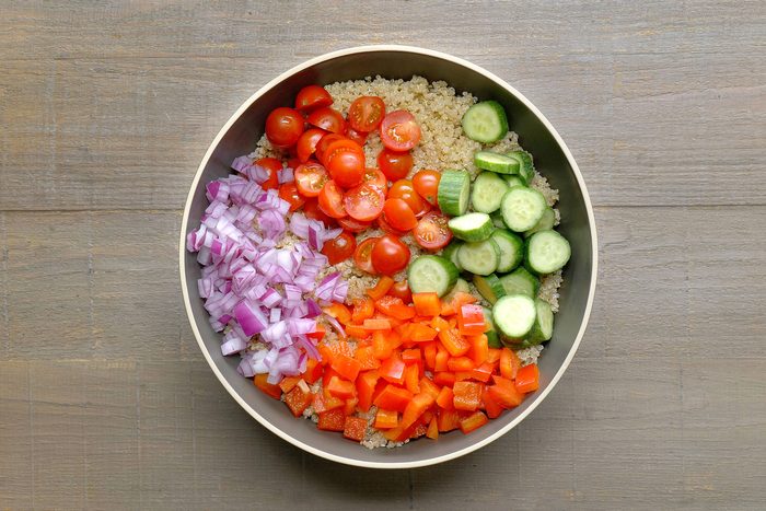 Quinoa and vegetables mixed in a large bowl.