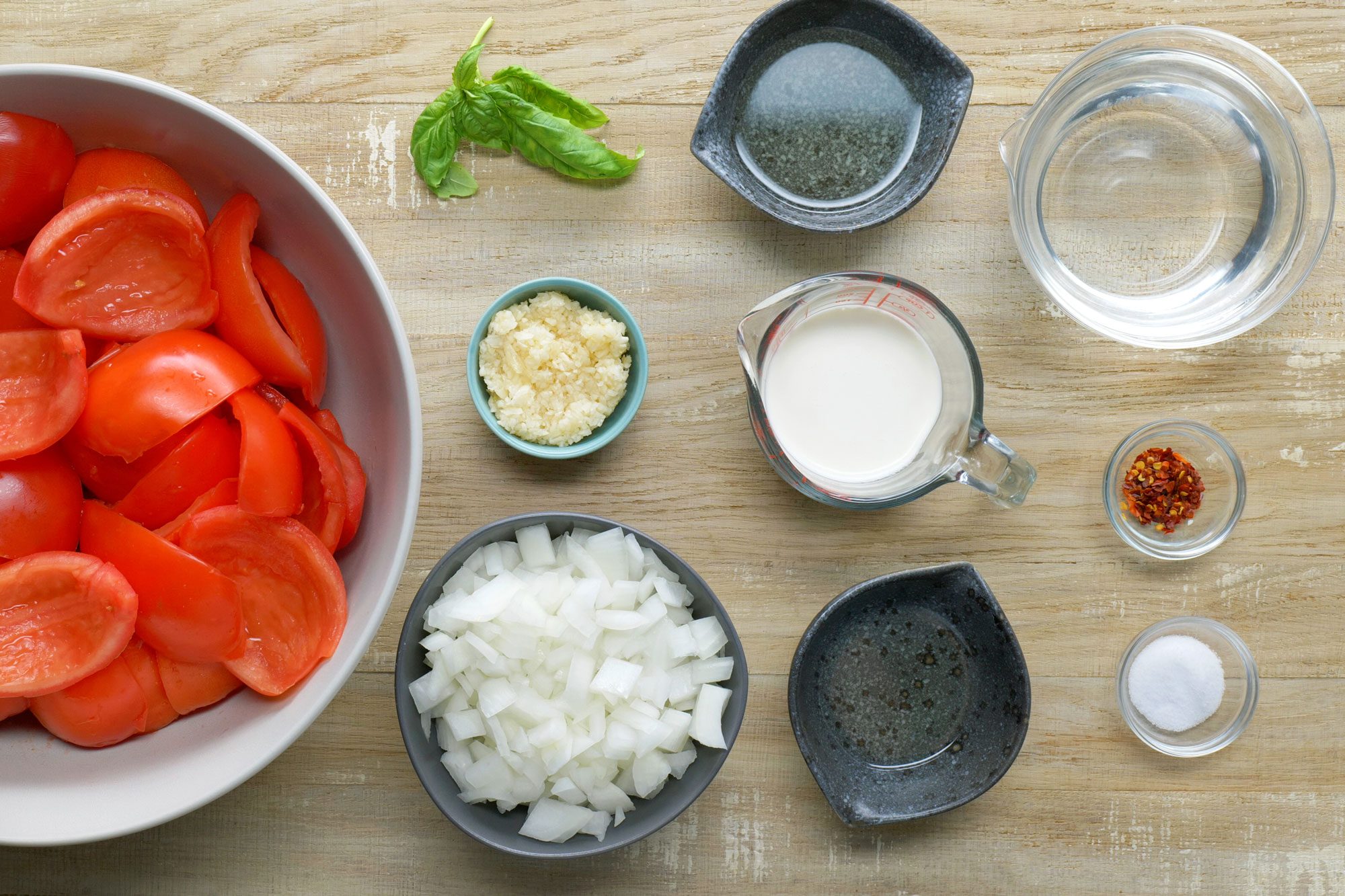 overhead shot of ingredients for Roasted Tomato Soup; Wooden Background;