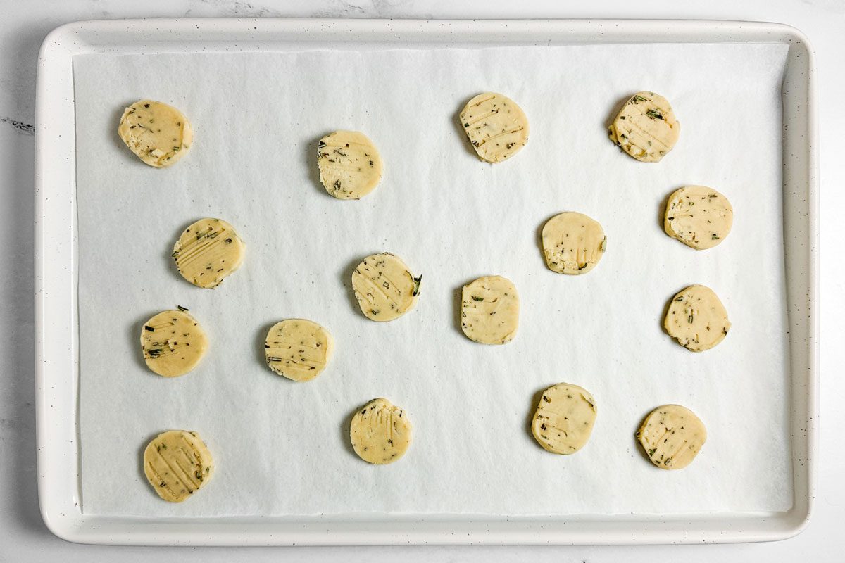 Unbaked Taste of Home Rosemary Shortbread Cookies on a white baking sheet