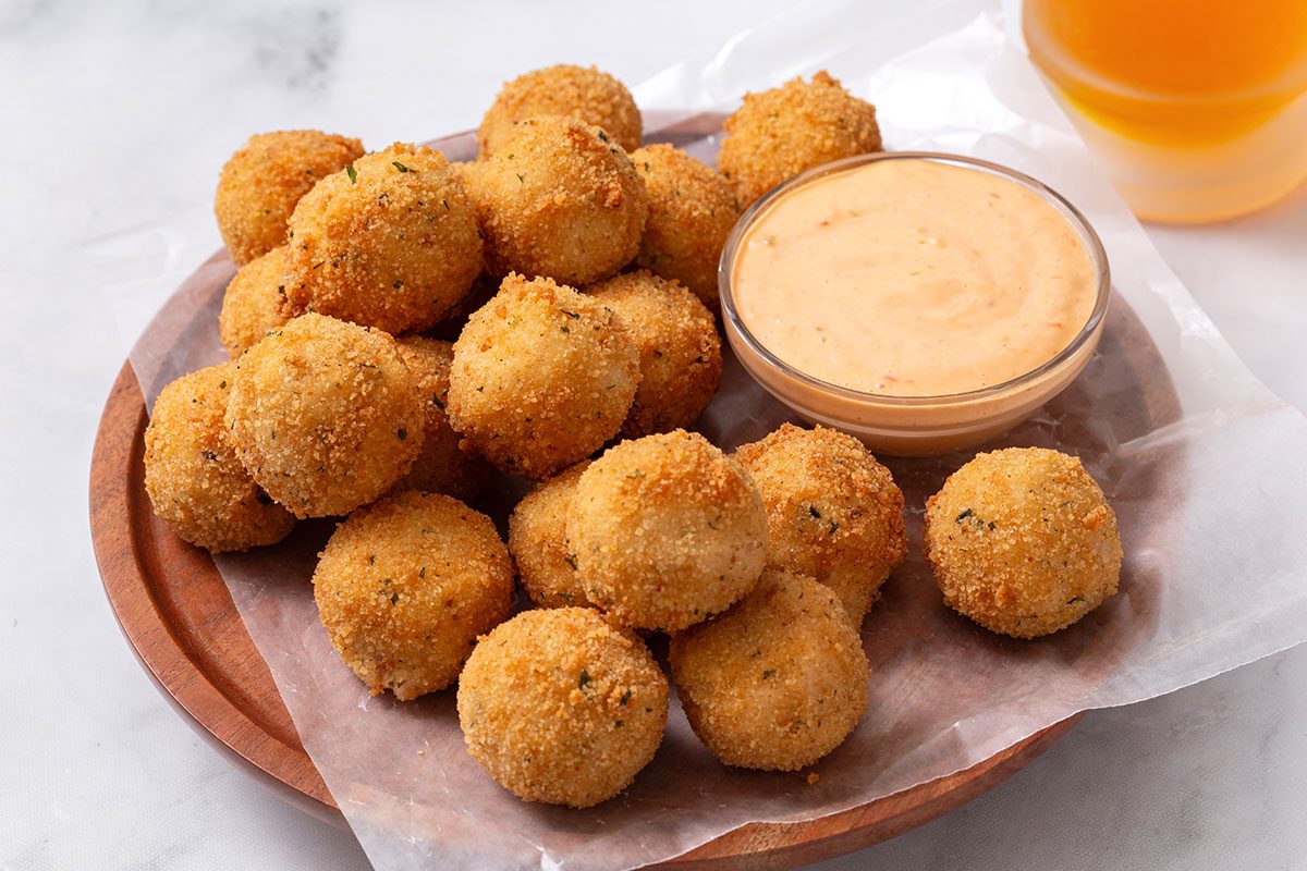 Sauerkraut Balls on a plate with dipping sauce for Sauerkraut Ball recipe for Taste of Home