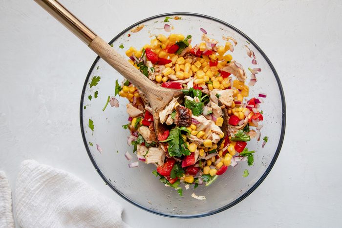 Overhead beauty shot for Taste of Home Southwest Chicken Salad, ingredients in a glass bowl mixed.