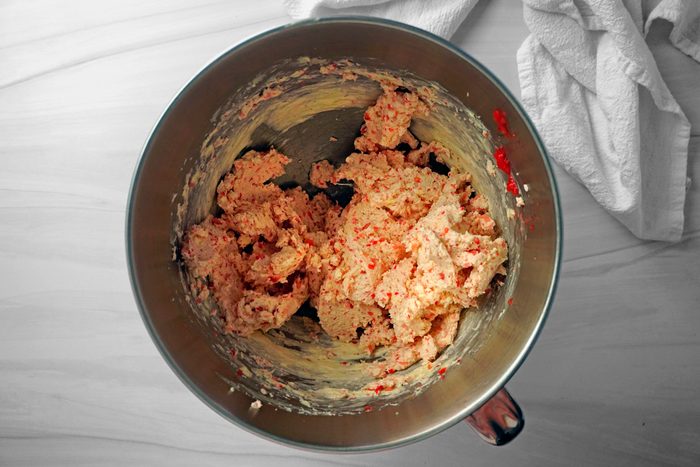 Adding blended stawberry into the butter mixture