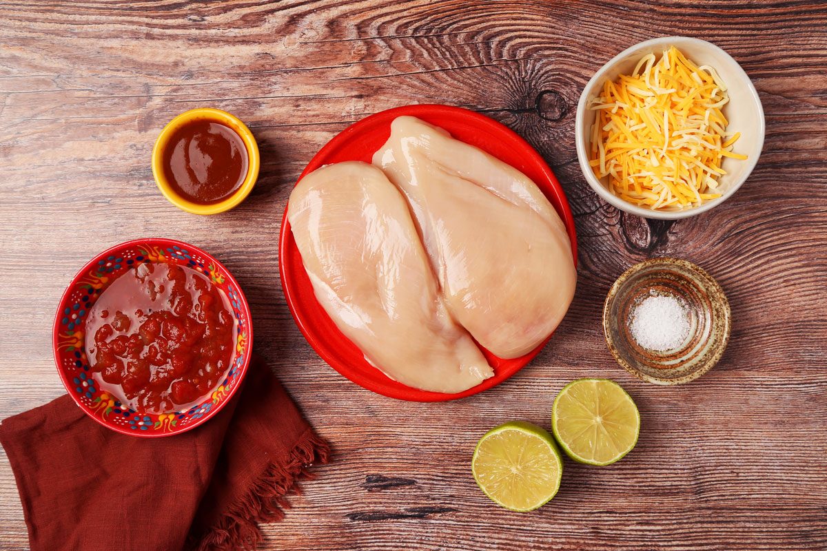 Ingredients for Taste of Home's Salsa Chicken in small dishes on a wooden surface.
