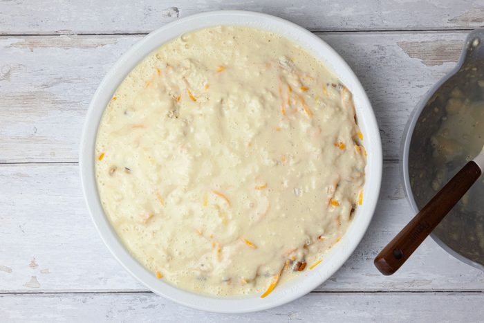 Step 4 of Taste of Home Taco Pie is to whisk together the eggs and milk. Add the biscuit mix and stir just until combined, making sure not to overmix. Pour this mixture evenly over the cheese layer on the pie plate.