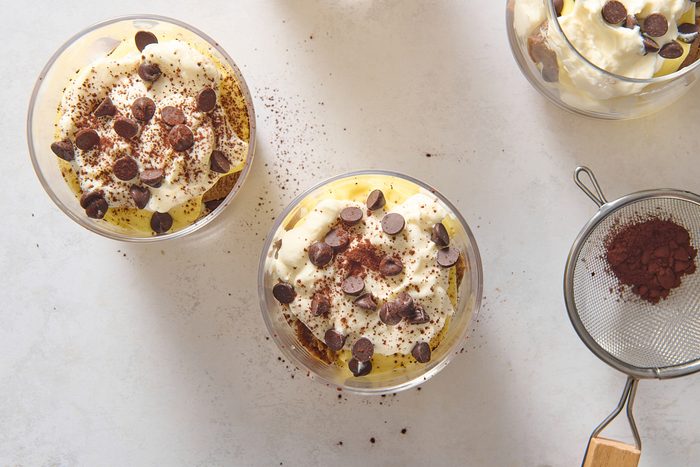 Chilled Tiramisu Cups being sprinkled with cocoa