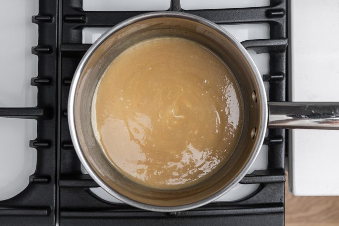 Sauce for white chocolate bread pudding being prepared in sauce pan.