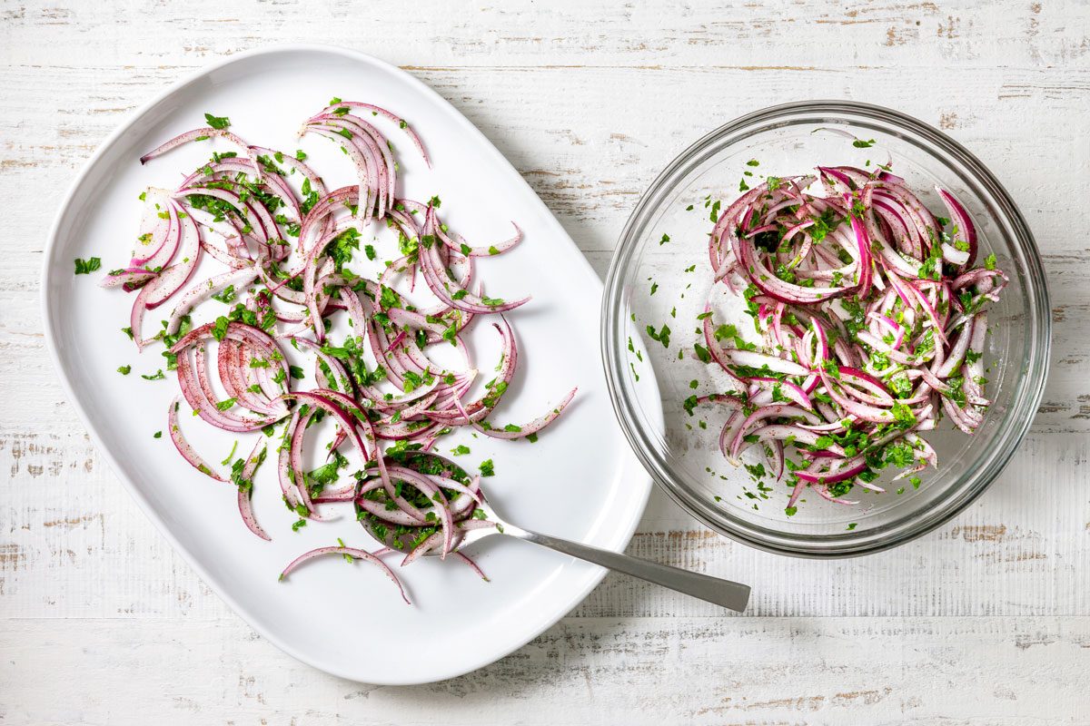 In a large bowl, combine red onion, parsley, oil, sumac and salt; toss to coat. Arrange on a large serving platter.