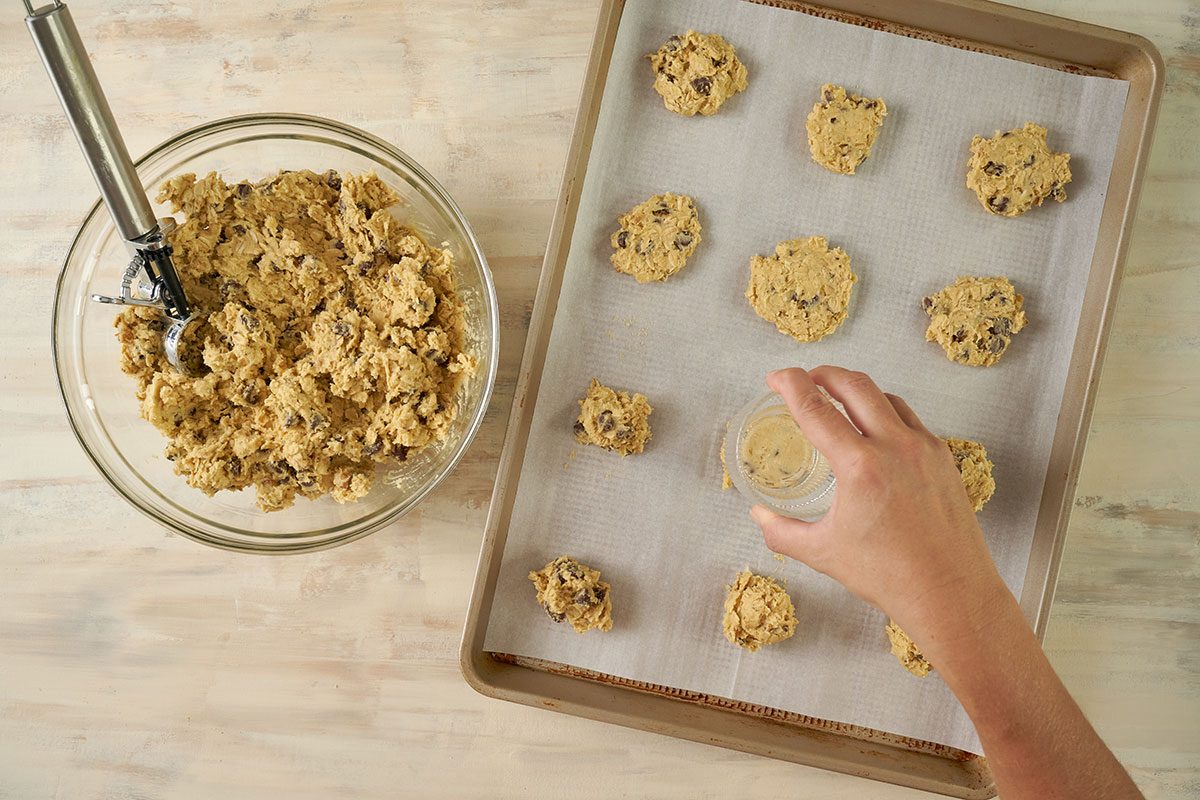 Overhead view of cookie dough portions placed being pressed and ready to cook in airfryer until golden brown for the Taste of Home Air Fryer Oatmeal Cookies recipe.