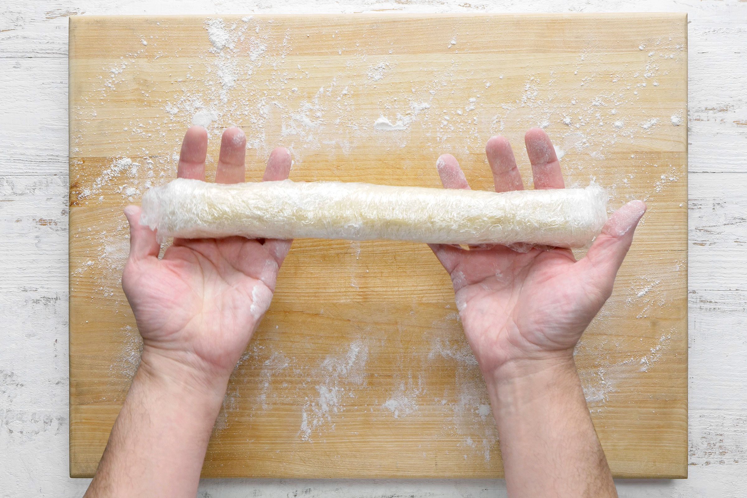 Rolled cookie dough ball into a log shape and tightly wrapped in storage wrap