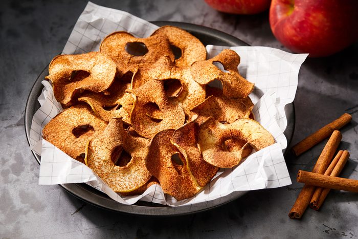 Apple Chips arranged on a piece of parchment paper and sprinkled with cinnamon