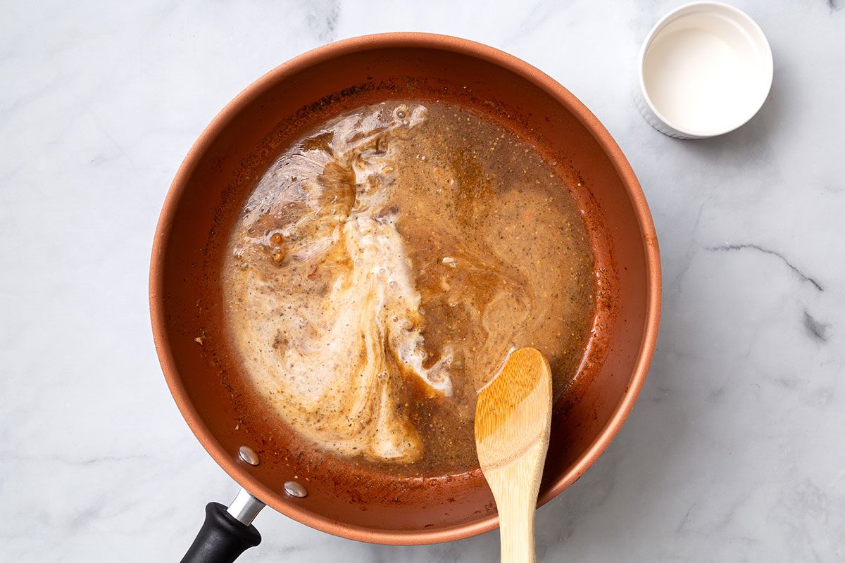 Cornstarch and water mixture added into apple cider sauce in large skillet for step three for Apple Cider Pork Chops recipe for Taste of Home