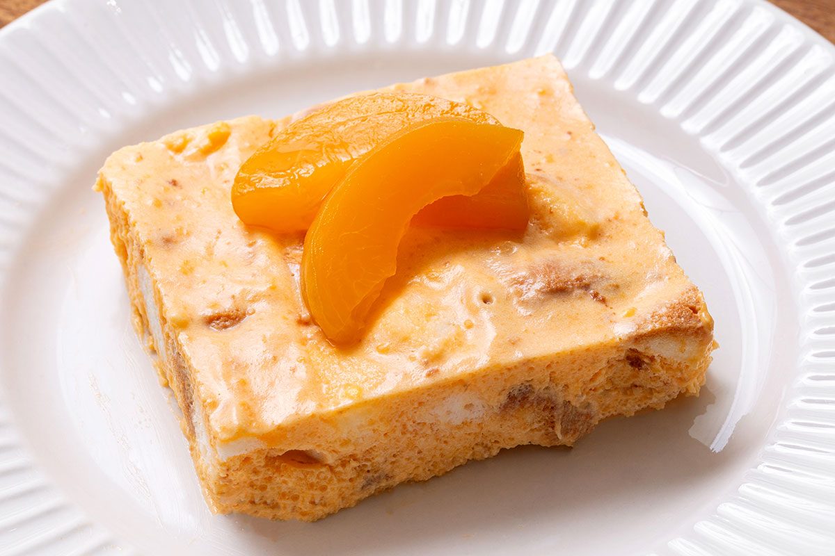 Piece of Apricot Delight topped with apricot slices on a plate for Taste of Home