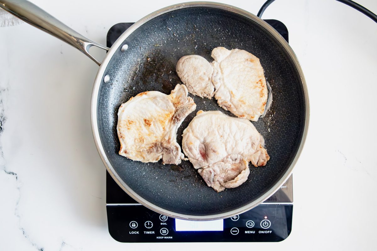 Overhead shot for Taste of Home BBQ Pork Chops in a HexClad pan over an induction cooktop.