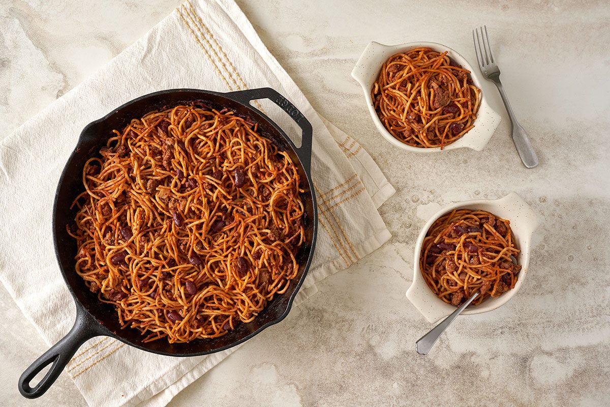 An overhead of the Baked Chili Spaghetti, hot from the oven, featuring spaghetti, kidney beans, and seasoned beef in a tomato sauce, by Taste of Home.