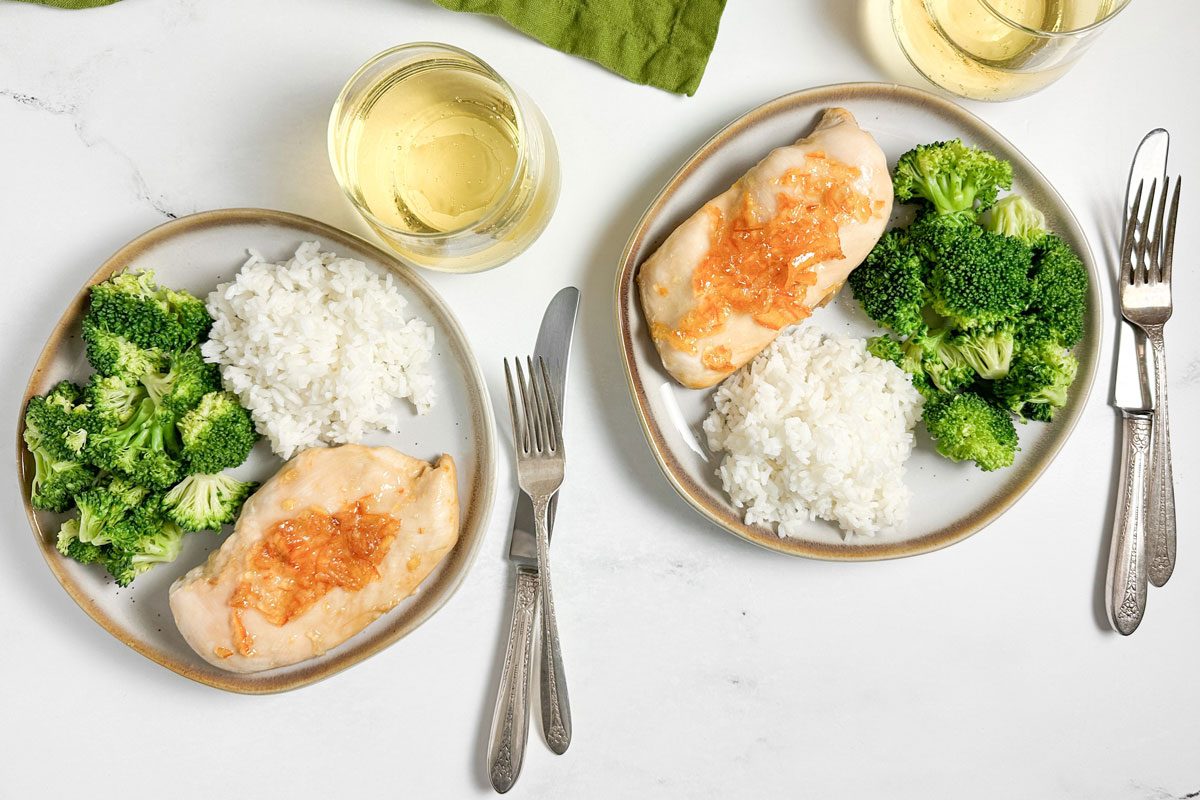 Taste of Home Baked Orange Chicken on ceramic plates with white rice and steamed broccoli