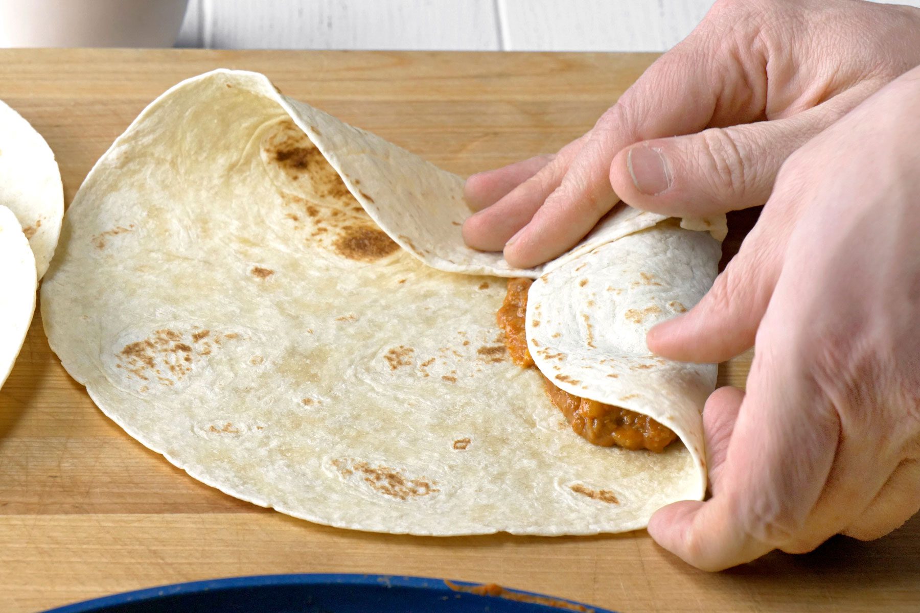 Tortilla being folded with ebef inside.