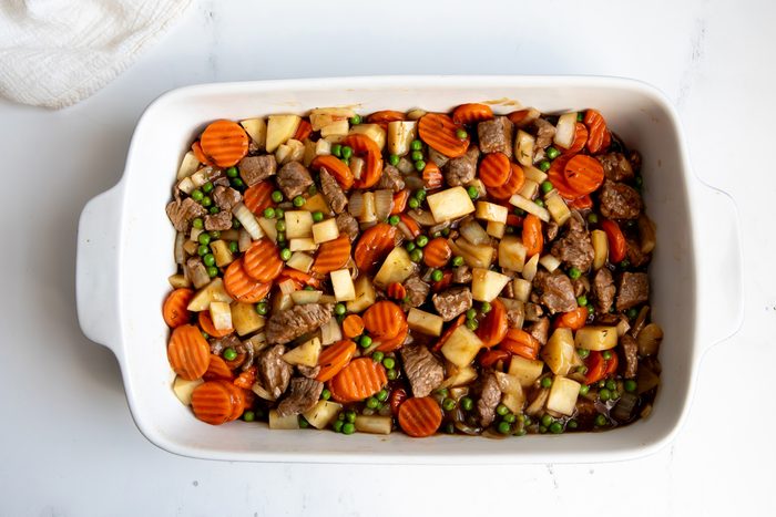 Overhead shot for Taste of Home Beef Potpie with Biscuits, ingredients in a baking dish.