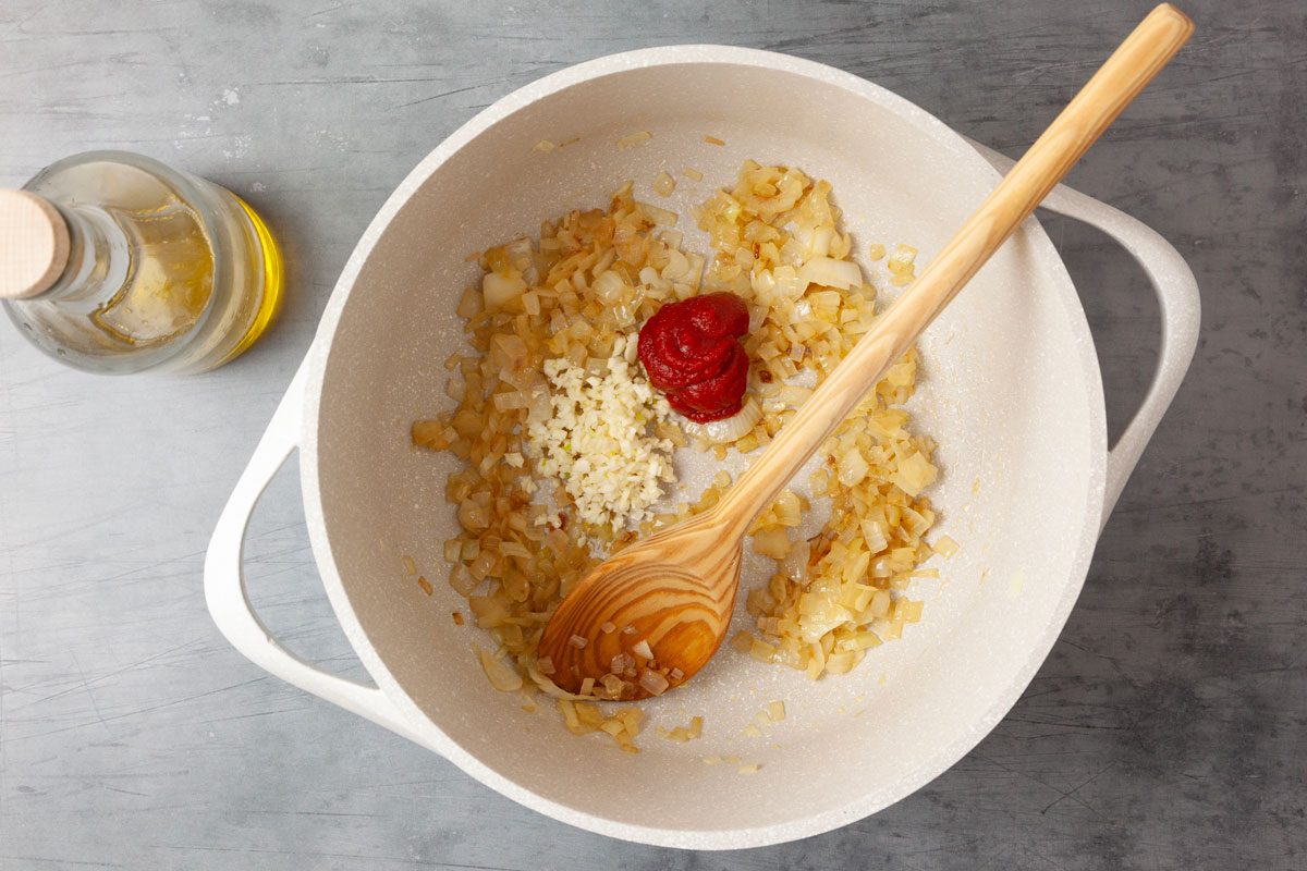 Step 1 of Taste of Home British Baked Beans is to In a large saucepan, heat the olive oil over medium heat. Add the chopped onion and fry for four to five minutes until soft and a little crispy. Add minced garlic and tomato paste, stir and fry one minute longer.