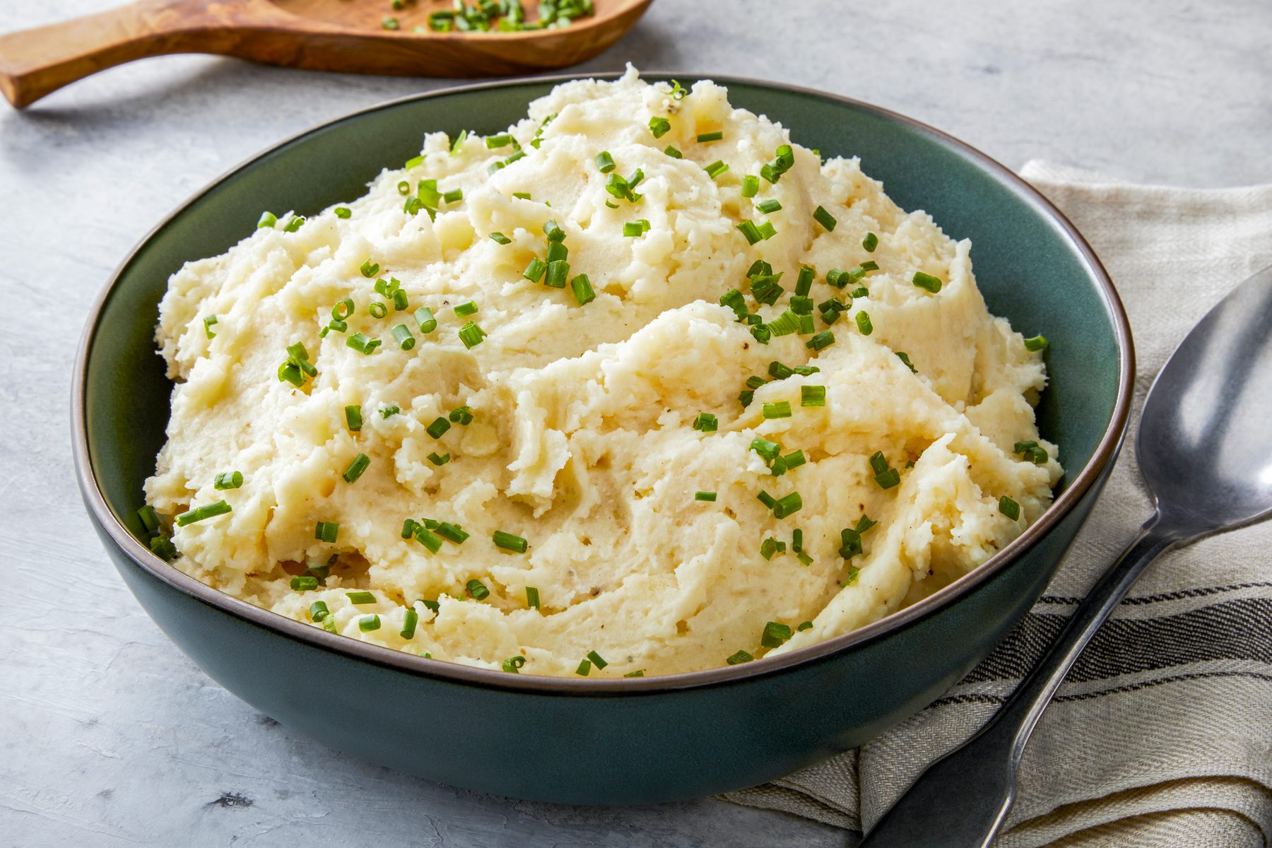 A 3/4 angle view of a serving bowl filled with creamy browned butter mashed potatoes.