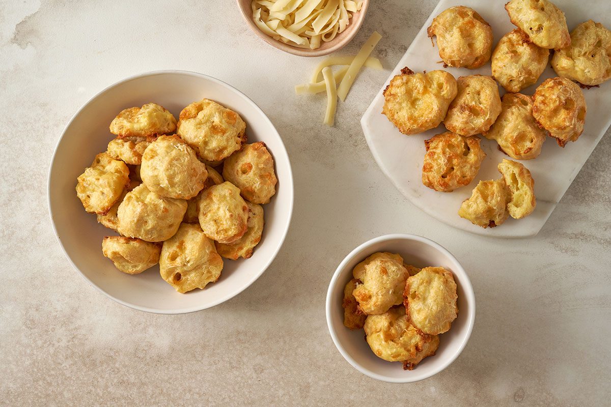 An overhead view of baked Cheese Puffs, golden brown and ready to serve, arranged on a plate, by Taste of Home.