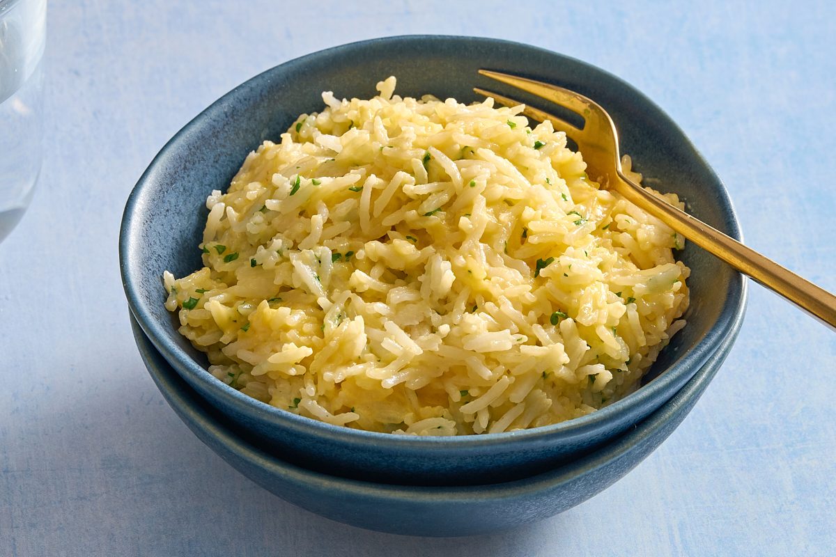 Angled shot of a bowl of cheesy rice with a fork