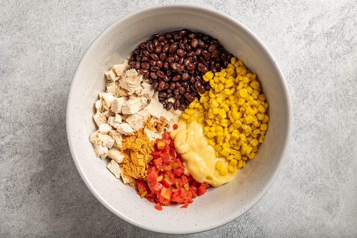 Taste of Home Chicken Doritos Casserole photo of the ingredients, minus the Doritos, sour cream, salsa and cilantro, in a mixing bowl.