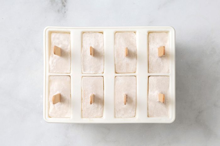 Solid coconut popsicles in molds for step 3 in Coconut Popsicles for Taste of Home