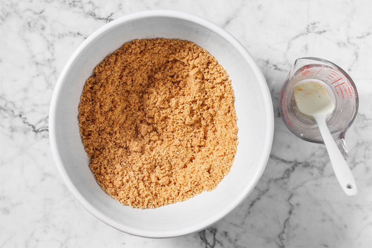 In A Large Bowl, Combine Graham Cracker Crumbs And Sugar