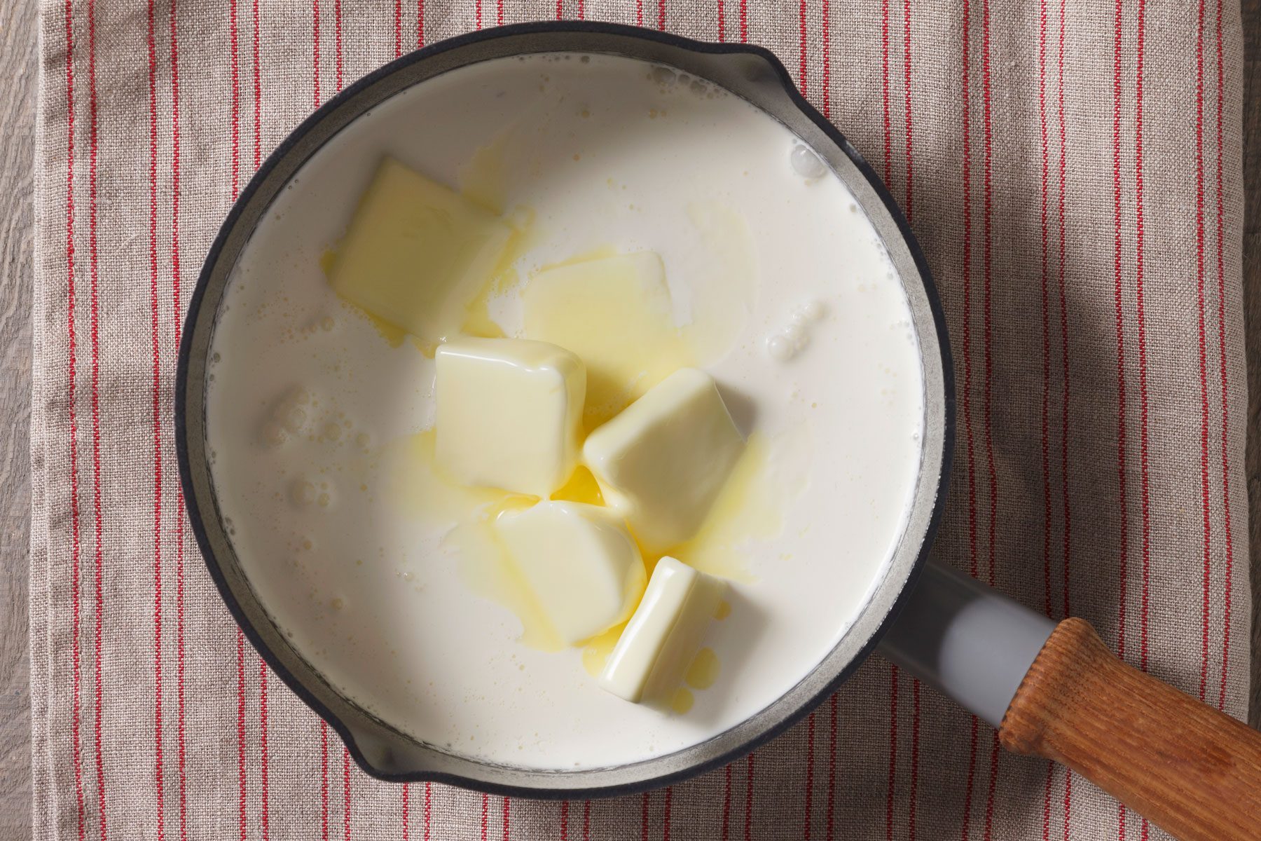 milk, cream and butter mixture being heated in a large bowl.