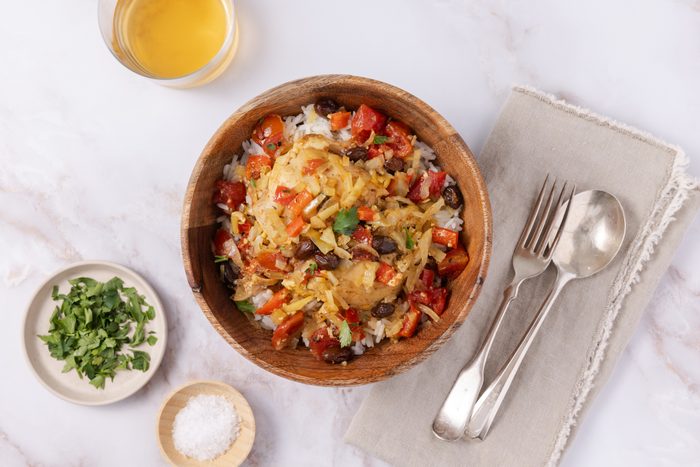 Country captain chicken ready and served in wood bowl with rice.