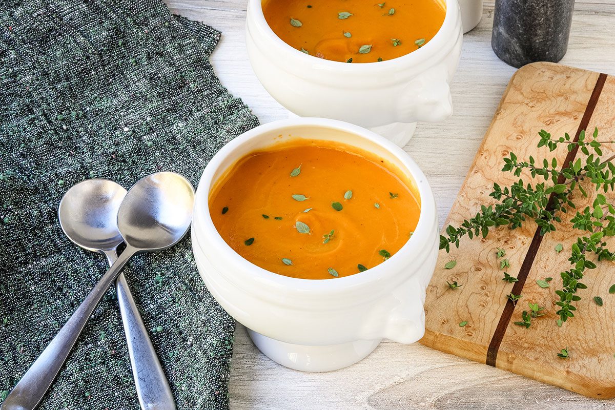 Creamy carrot soup with thyme leaves.