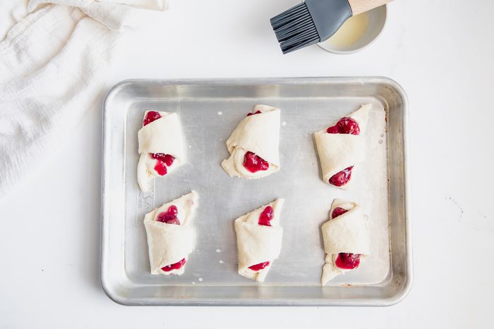 Overhead shot for Taste of Crescent Rolls with Cherry Pie Filling, unbaked crescent rolls with cream cheese and cherry filling inside.