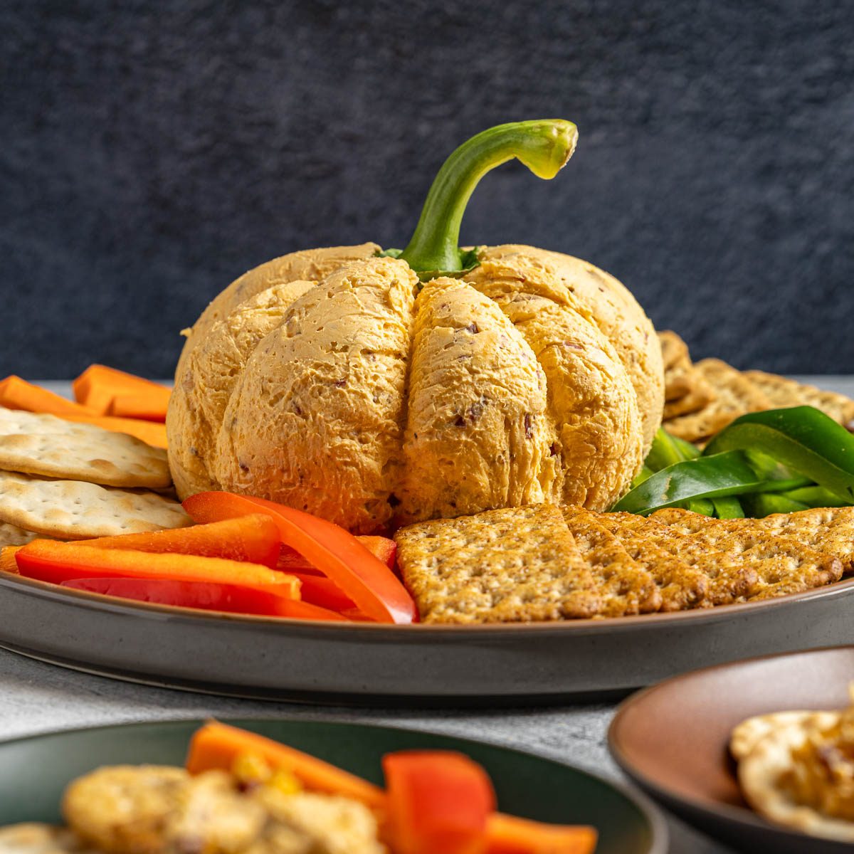 Taste of Home Pumpkin Cheese Ball photo of the finished recipe served with crackers and fresh vegetables.