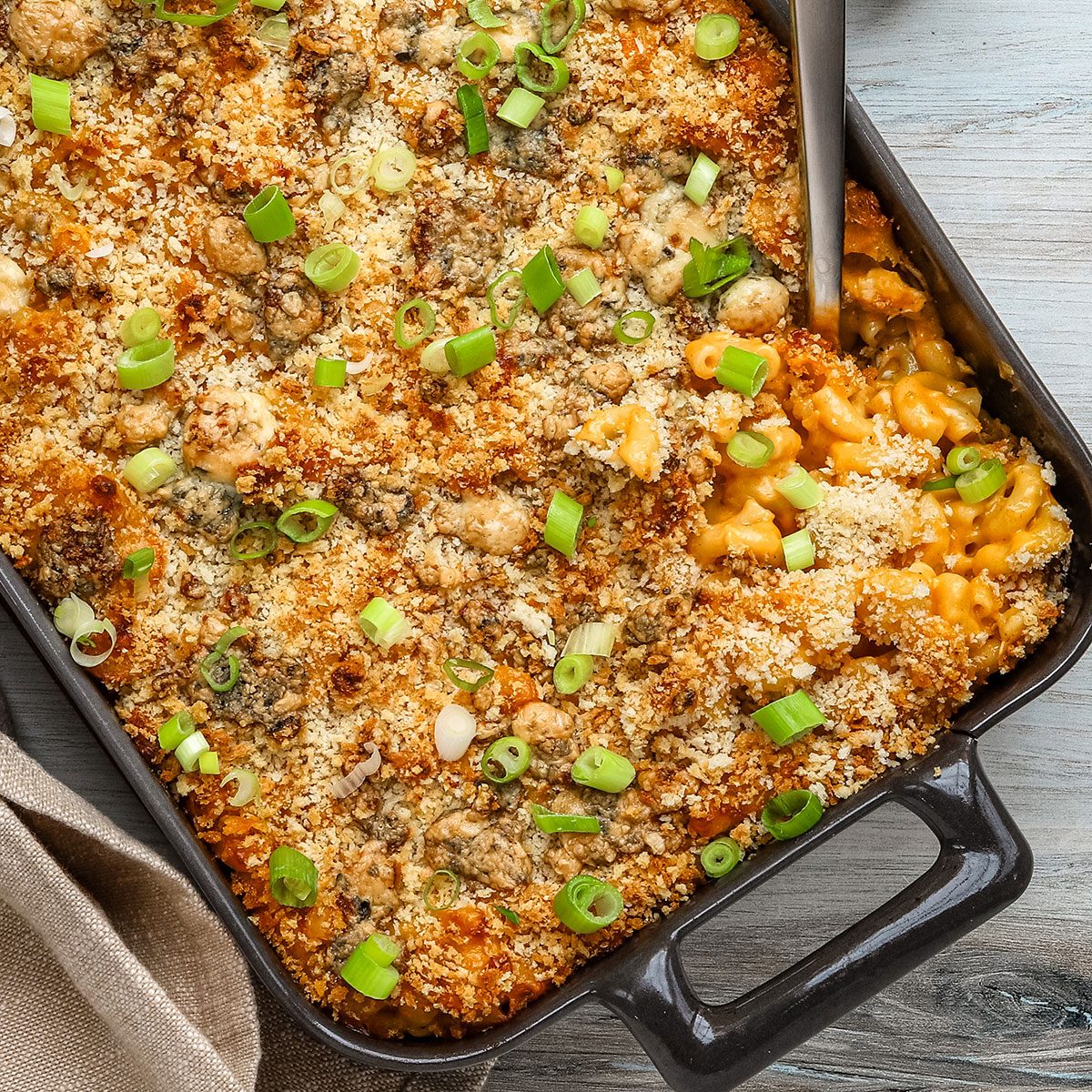 A baking dish of Buffalo mac and cheese topped with panko, blue cheese, and green onions, a recipe from Taste of Home.