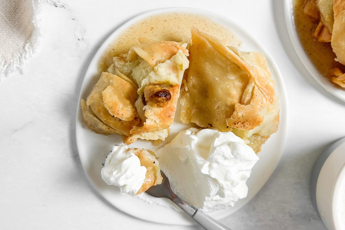 Taste of Home Easy Apple Dumplings on white plates with whipped cream