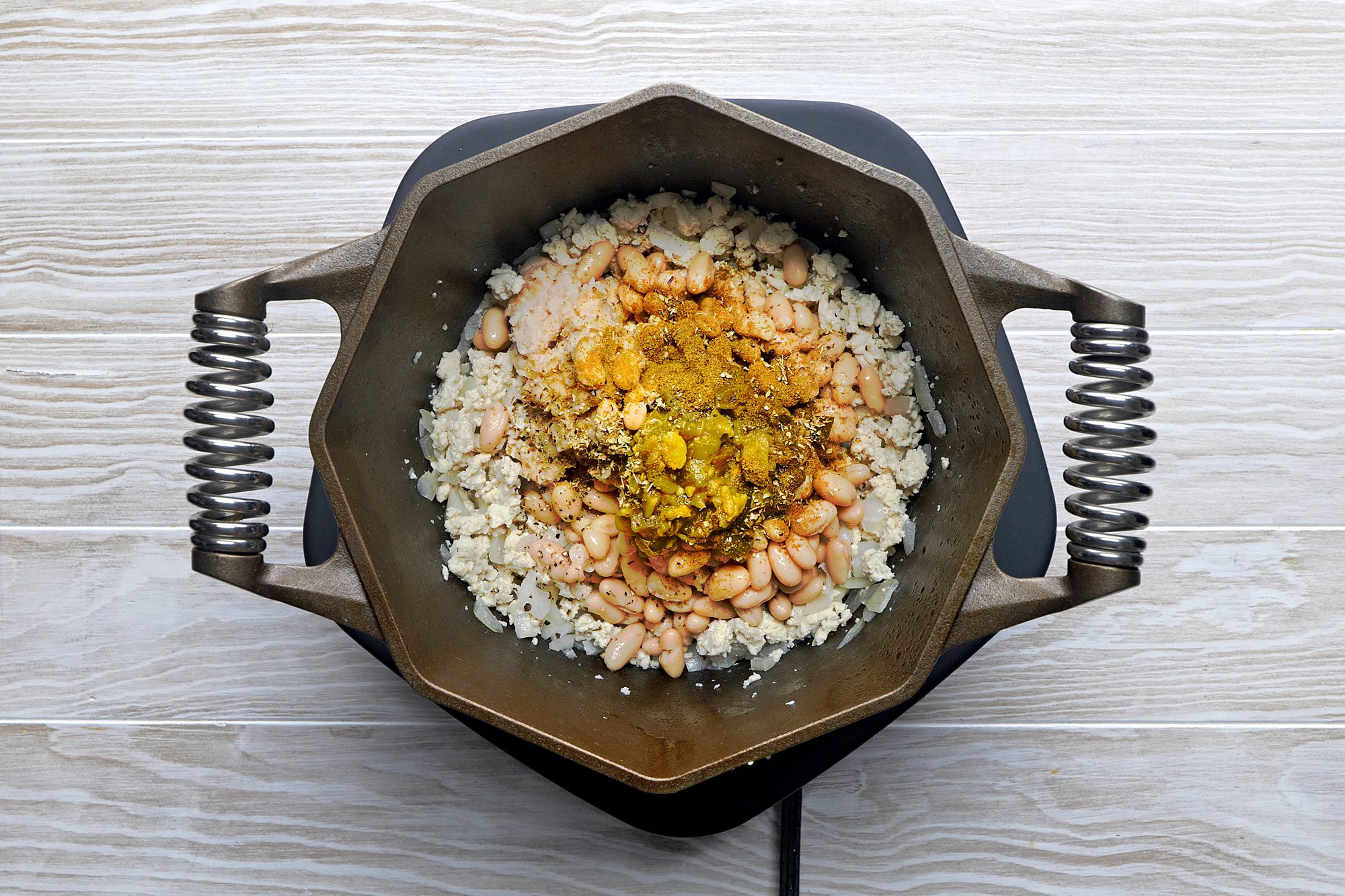 Stir mashed beans, remaining can of beans, chiles, seasonings and broth into chicken mixture