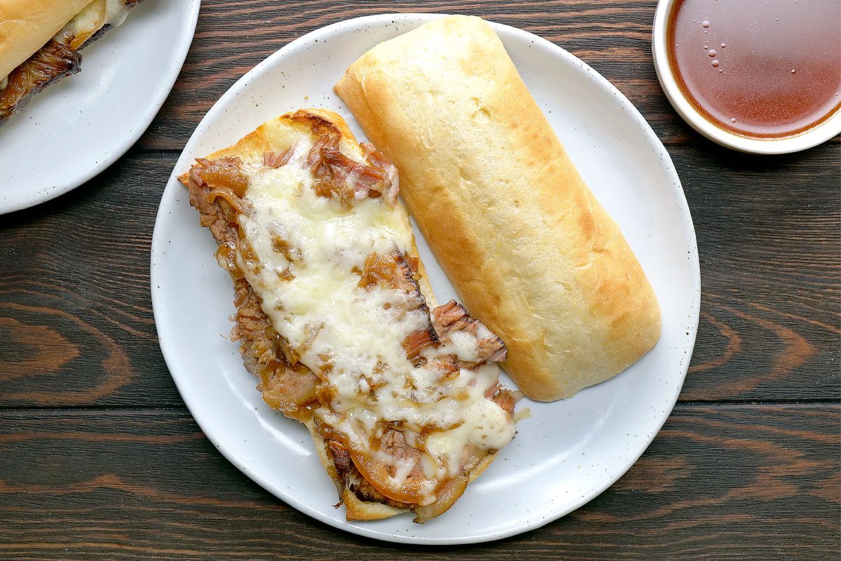 Overhead Shot Of French Dip Sandwiches With Onions