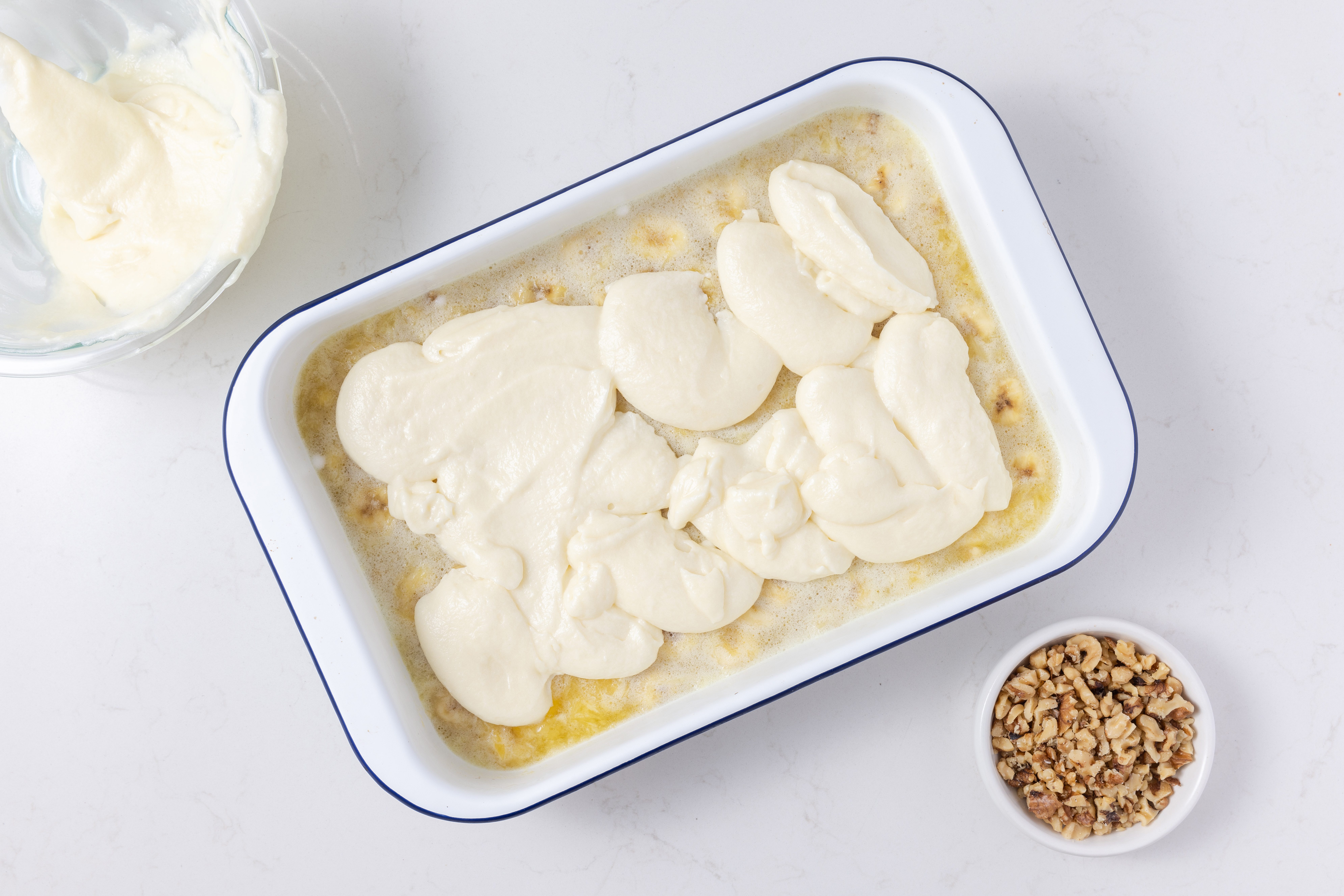 Topping being spread on gelatin mixture to finish assembling the dessert.