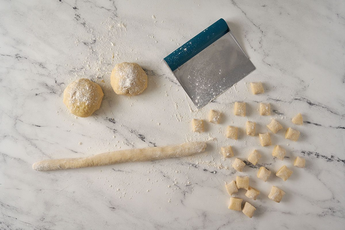 Mix potato flakes with boiling water, eggs, flour, and salt to form a dough. Roll the dough into ropes and cut into pieces for the homemade gnocchi in this Gnocchi Bolognese by Taste of Home.