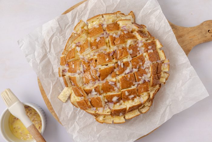 Hawaiian sweet bread filled with cheese and beign brushed with garlic and onions butter.