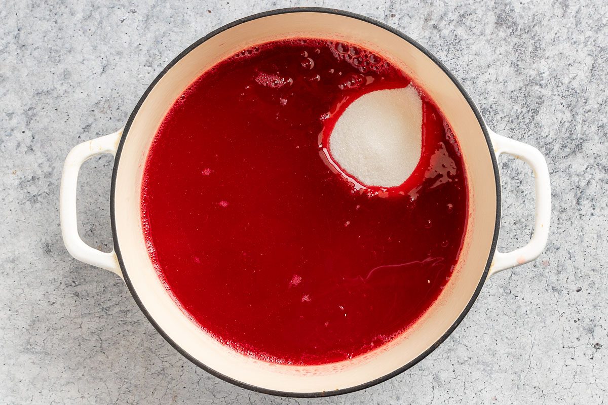 adding the sugar, lemon and orange juice to the cranberry juice.