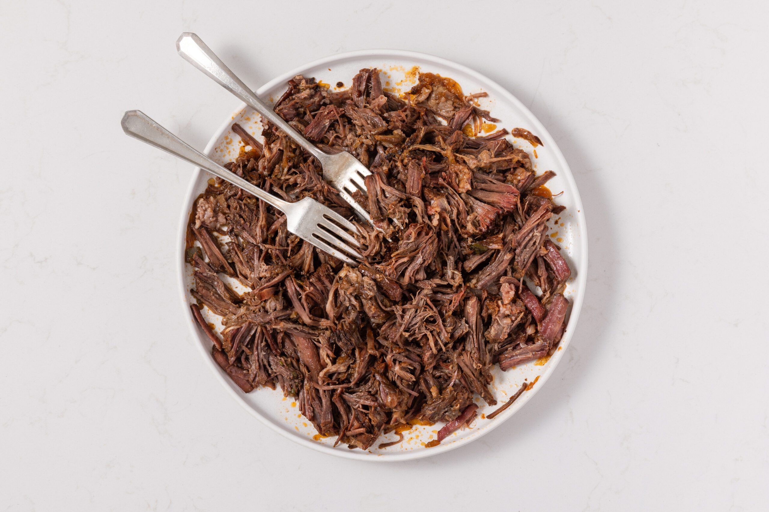 Beef chuck roast shredded after being cooked in the instant-pot.