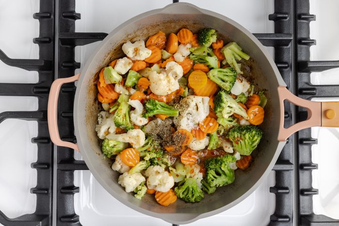Italian salad dressing, dried oregano and dried basil combined with vegetables in skillet.