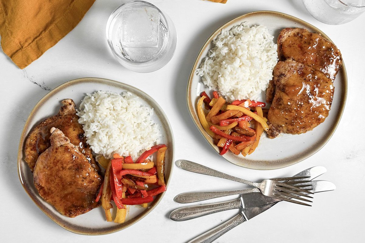 Taste of Home Jamaican Jerk Pork Chops on ceramic plates with rice and peppers