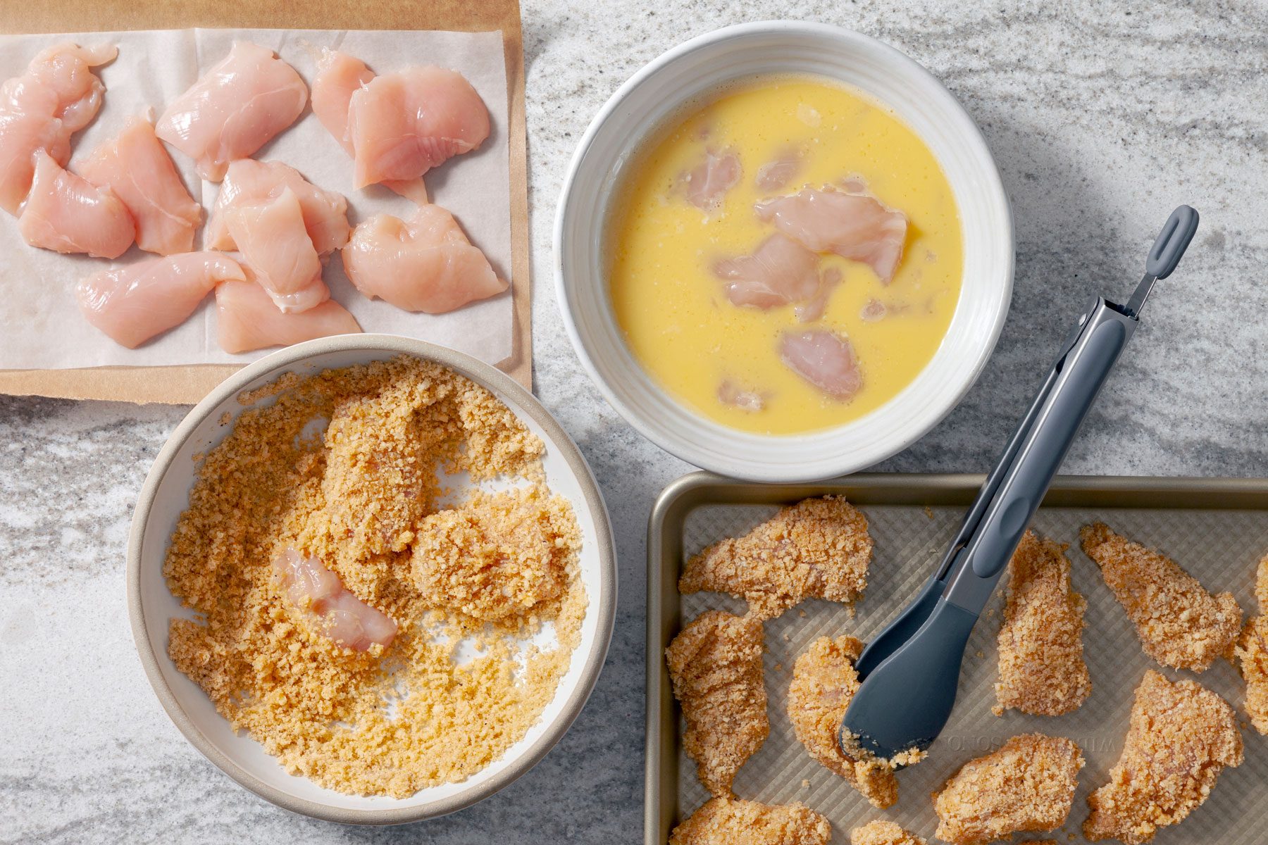 Chicken nuggets dipped in beaten eggs in one bowl. In another bowl they are dredged in keto breading mixture.