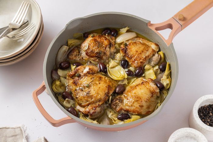 Mediterranean chicken thighs ready served on skillet.