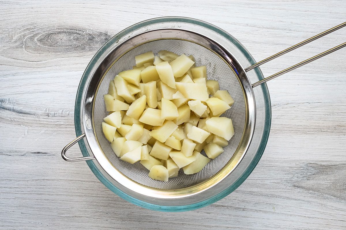 Draining the microwave-cooked potatoes.